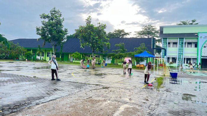 OSIM MAN 2 Kota Jambi Sigap Keringkan Lapangan Usai Diguyur Hujan Demi Clasmeet Tetap Maksimal